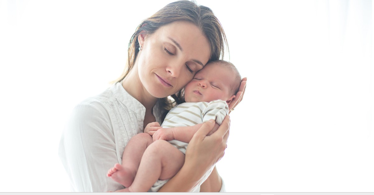 Mother gently holding her newborn baby close to her chest